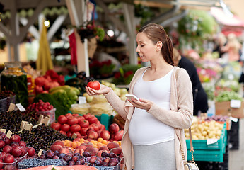 Image showing pregnant woman with smartphone at street market
