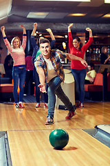 Image showing happy young man throwing ball in bowling club