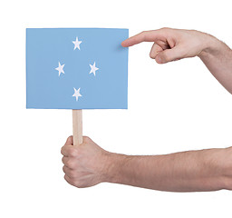 Image showing Hand holding small card - Flag of Micronesia