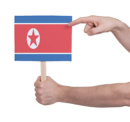 Image showing Hand holding small card - Flag of North Korea