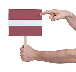 Image showing Hand holding small card - Flag of Latvia