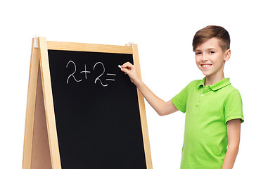 Image showing happy boy solving math on school blackboard