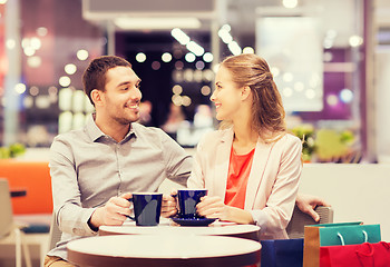 Image showing happy couple with shopping bags drinking coffee