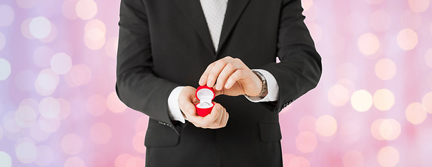 Image showing close up of man with gift box and engagement ring