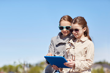 Image showing happy girls with tablet pc computer outdoors