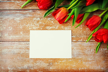 Image showing close up of red tulips and blank paper or letter