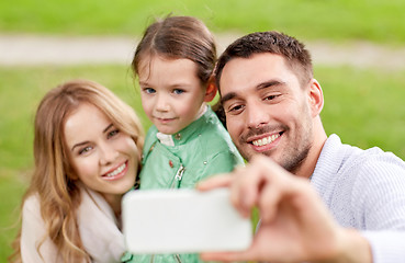 Image showing happy family taking selfie by smartphone outdoors