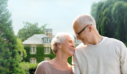 Image showing senior couple hugging over living house background