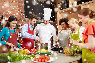 Image showing happy friends and chef cook cooking in kitchen