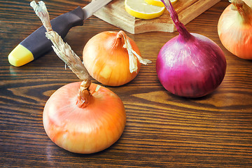 Image showing The still life: large onion and lemon on the table.
