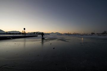 Image showing Fisherman Pulling his Sled on Ice to Catch Fish