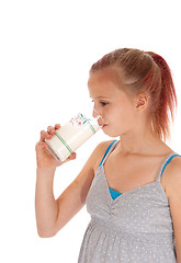 Image showing Young girl drinking a glass of milk.