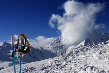 Image showing Ski mask on ski poles and off-piste slope