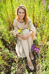 Image showing Beautiful sad girl sitting on meadow