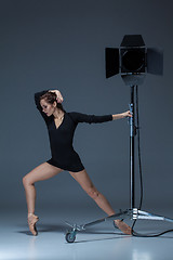 Image showing The beautiful ballerina posing on dack blue background  