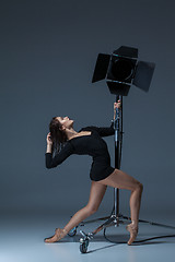 Image showing The beautiful ballerina posing on dack blue background  