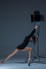 Image showing The beautiful ballerina posing on dack blue background  