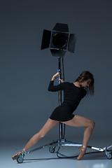 Image showing The beautiful ballerina posing on dack blue background  