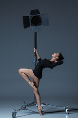 Image showing The beautiful ballerina posing on dack blue background  