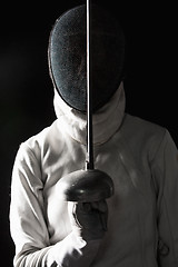 Image showing The portrait of woman wearing white fencing costume  on black 