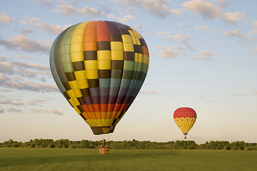 Image showing Two hot-air balloons in a field