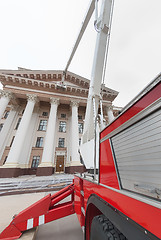 Image showing Builders paint building facade by fire truck