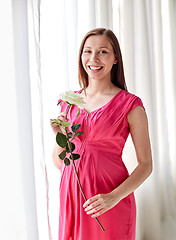 Image showing happy pregnant woman with rose flower at home