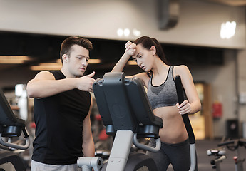 Image showing woman with trainer exercising on stepper in gym