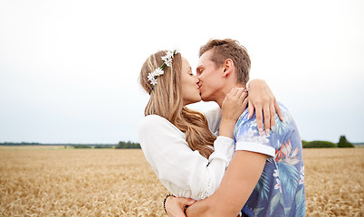 Image showing happy young hippie couple kissing in field