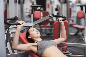 Image showing young woman exercising on gym machine