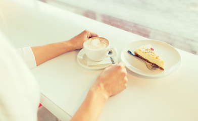 Image showing close up of woman hands with cake and coffee