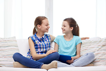 Image showing happy girls with tablet pc talking at home