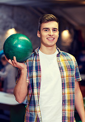 Image showing happy young man holding ball in bowling club