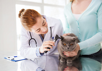 Image showing happy woman with cat and doctor at vet clinic