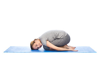 Image showing happy woman making yoga in child pose on mat