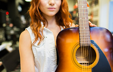 Image showing close up of woman with guitar at music store