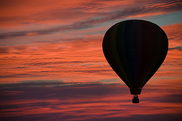 Image showing Hot-air ballooning among pink and orange clouds 