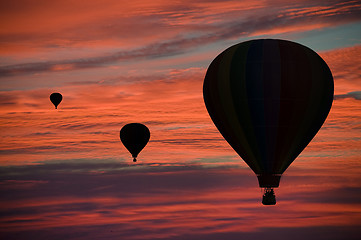 Image showing Hot-air balloons floating among clouds at dawn