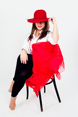 Image showing Young attractive woman with hat on chair