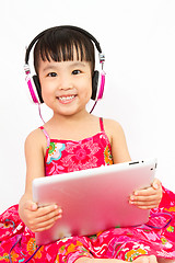 Image showing Chinese little girl on headphones holding tablet