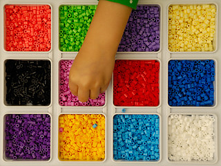 Image showing Child playing with toy pearls