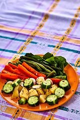 Image showing Ladle of steamed freshly harvested young vegetables including crinkle cut sliced carrots, peas and potato batons