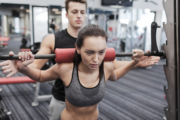 Image showing man and woman with barbell flexing muscles in gym