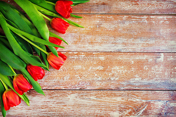 Image showing close up of red tulips on wooden background