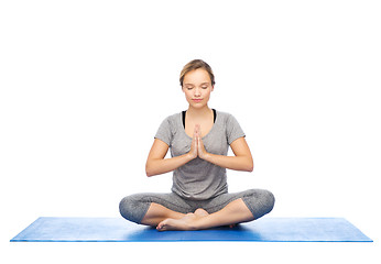 Image showing woman making yoga meditation in lotus pose on mat