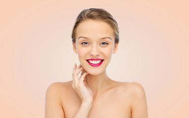 Image showing smiling young woman with pink lipstick on lips