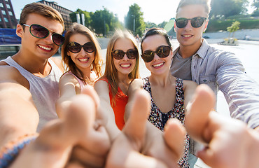 Image showing happy friends taking selfie and showing thumbs up