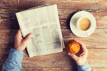 Image showing close up of male hands with newspaper and coffee