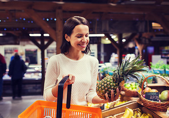 Image showing happy young woman with food basket in market