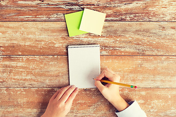 Image showing close up of hands with notebook and stickers